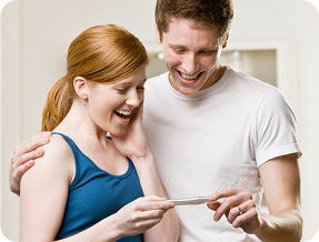 Молодая пара смотрит на тест на беременность