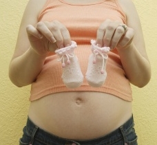 носочки для новорожденного в руках у беременной